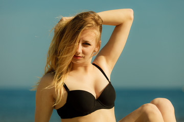 Woman in bikini sunbathing and relaxing on beach
