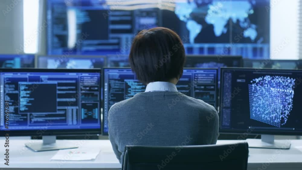 Poster In the System Control Room Technical Operator Works at His Workstation with Multiple Displays Showing Graphics. IT Technician Works on Artificial Intelligence, Big Data Mining, Neural Network Project.