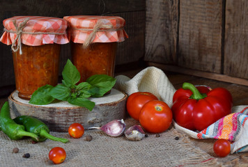 Jars of tomato sauce with chili, pepper and garlic. Bolognese sauce, lecho or adjika. Preservation. Canning