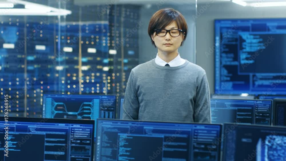 Poster In the System Control Room Technical Operator Stands and Looks at the Camera. He's Surrounded by Multiple Displays Showing Graphics.  Shot on RED EPIC-W 8K Helium Cinema Camera.
