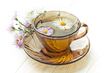 Tea in a cup on a metallic background in a composition with a cookware