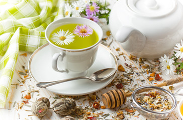 Tea in a cup on a metallic background in a composition with a cookware