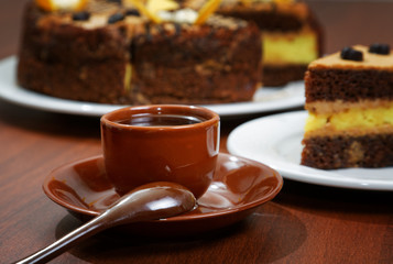 Fototapeta na wymiar cake with a brown cup of coffee on the table