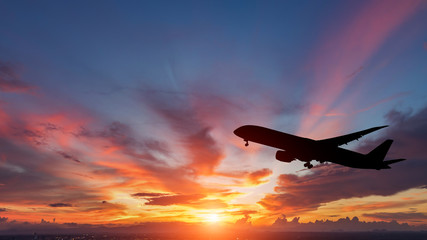 Fototapeta premium Sylwetka samolotu pasażerskiego lecącego w zachód słońca.