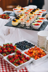 Square bowls with strawberries, blueberries and cherries stand on the table