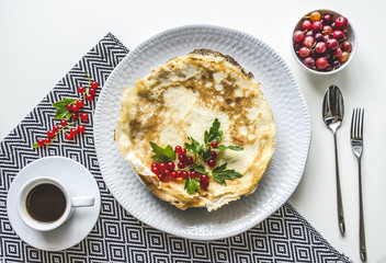 Pancakes. Table setting with pancakes. Pancakes with berries and coffee on a nice plate. View from above.