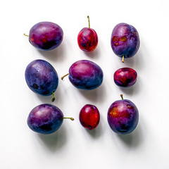 Square of fresh plums.  Food Photo. Creative scheme of whole plums on white background. View from...