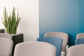 sillas azules y grises agrupadas en una sala de conferencia para una chala informal