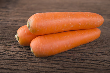 pile of fresh carrots on wooden background