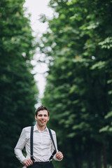Young man in braces stands in the forest