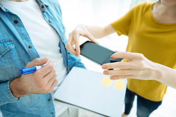 Close up of people photographing notes in notebook