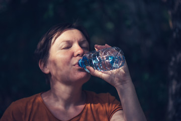 Woman drinking water outdoors