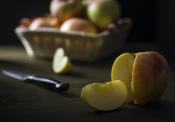 The Apple slices are on the background of the basket of apples.