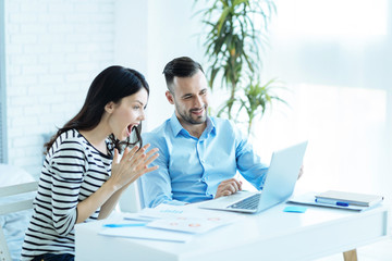 Male employee sharing positive news with colleague