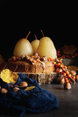 Fototapeta na wymiar Autumn meal. Pie with pears, sea buckthorn and nuts. Dark background.