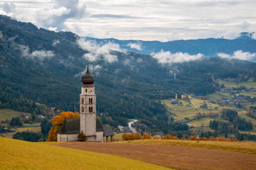 Traditional Tyrol church in the foothills of the Dolomites on rural mountain background