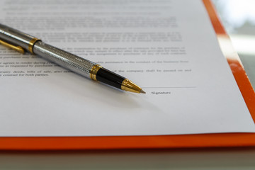 A pen on contract paper preparation for signing a contract.