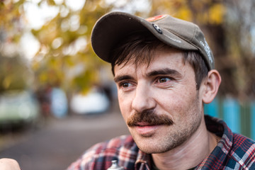 The man in the village in a cap with a mustache - obrazy, fototapety, plakaty