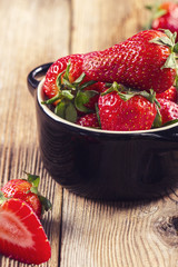 Strawberries in a black bowl closeup