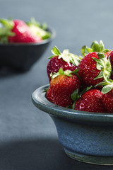 Strawberries in a stone bowl on a dark background