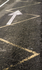 The marks on the asphalt road in the city. Arrow on asphalt