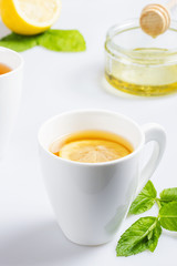 A cup of lemon tea with mint and honey