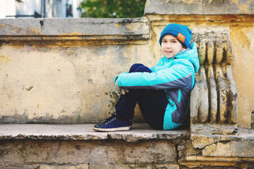 Fototapeta premium Young and happy young girl sitting on a bench in autumn Park
