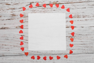 White sheet of paper on a white wooden background. Valentine's Day Concept