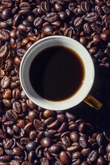 Cup of fresh coffee on coffee beans