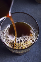 Pouring coffe into a glass, top view