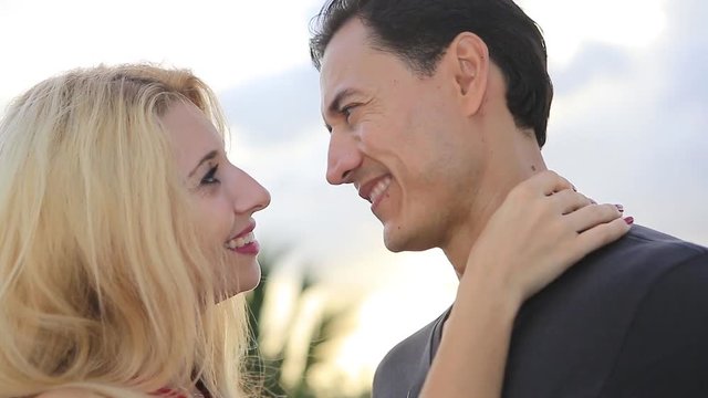 Young beautiful happy couple. Ukrainian girl and Mexican man. Look at each other, hugging, kissing, ...dancing on the roof in the caribbean resort