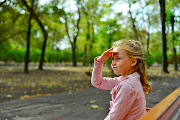 Fototapeta premium Girl sitting in a bench in the park