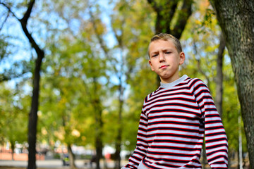The young guy sits on a bench in park