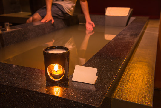 Aroma lamp with burning candle in bathroom