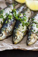 Grilled Sardines with Chopped Herbs and Lemon Wedges Wrapped in Brown Paper