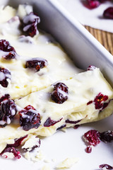 White chocolate with cranberries in a bowl closeup