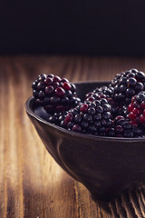 Blackberries in a bowl on a wooden table