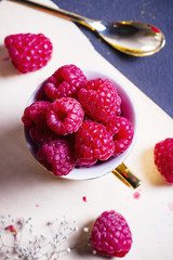 Fresh raspberries in a golden cup, view from top