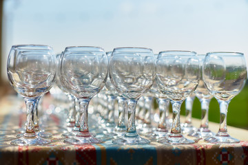 beautiful holiday table glasses of wine glassestwo rows of glasses on a table with a white tableclothglasses on high legsplaced a glass of wine on festive table
