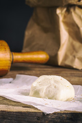 Fresh dough and rolling pin on wooden table
