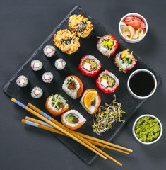 Sushi set, wasabi, ginger, soy sauce on black, view from top