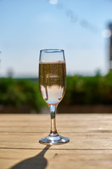 Glass with champagne on a wooden table.
