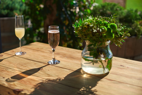 Cozy terrace, Glass with champagne on a wooden table.