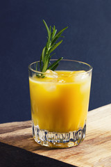 Orange and rosemary alcoholic drink on wooden board