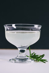 Alcoholic drink with rosemary on white table