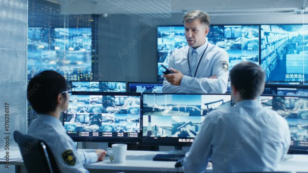 Aufkleber in the security control room chief surveillance officer holds a briefing for two of his subordinates