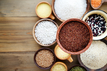 Cereals and legumes in bowls on wooden background.  Top view. Selective focus
