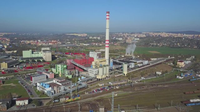 Flight over heating plant and thermal power station. Aerial view of combined modern power station for city district heating and generating electrical power. Industrial zone with railway in the city.