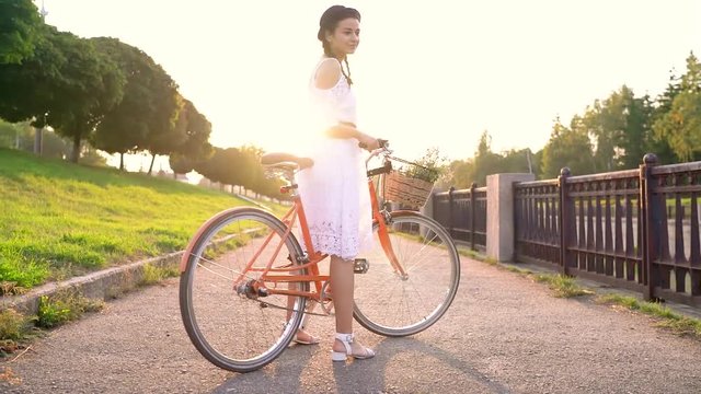 Young beautiful woman riding a bicycle at sunset