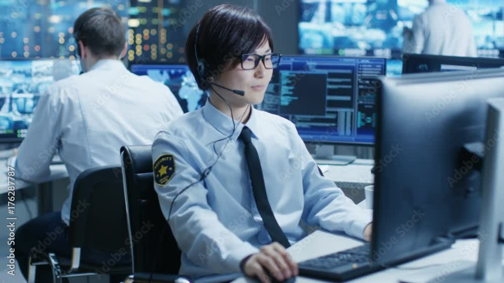 Poster In the Security Command Center Officer at His Workstation Monitors Screens and Communicates with Patrols through Headset. He is Part of the Surveillance Team. 